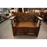ENGLISH GOTHIC OAK MONKS BENCH, THE LIFT-UP TOP/BACK HAVING TWO CARVED PANELS AND THE BASE HAVING