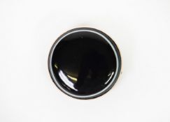 DOMED BLACK AGATE CIRCULAR BROOCH with natural white line border, in gold coloured metal frame, 1