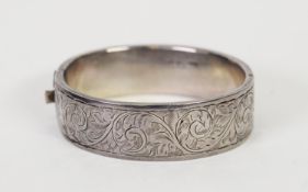 SILVER BROAD HINGE-OPENING HOLLOW BANGLE, with foliate scroll embossed top, Birmingham 1946