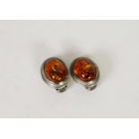 PAIR OF CLIP EARRINGS, each set with a cabochon oval transluscent golden amber