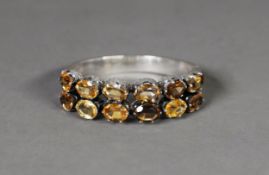 GOOD VICTORIAN SILVER HINGE OPENING BANGLE, the top with twelve oval citrines in two rows, with