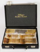 SIXTY SIX PIECE TABLE SERVICE OF CUTLERY WITH EMBOSSED GILT HANDLES BY SOLINGER, in a fitted black