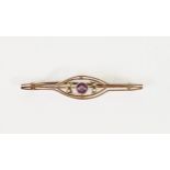 9ct GOLD OPENWORK BAR BROOCH, collet set with centre amethyst and flanked by two pairs of seed