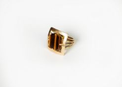 GOLD COLOURED METAL DRESS RING, set with a square tiger's eye stone, in a four claw setting with a