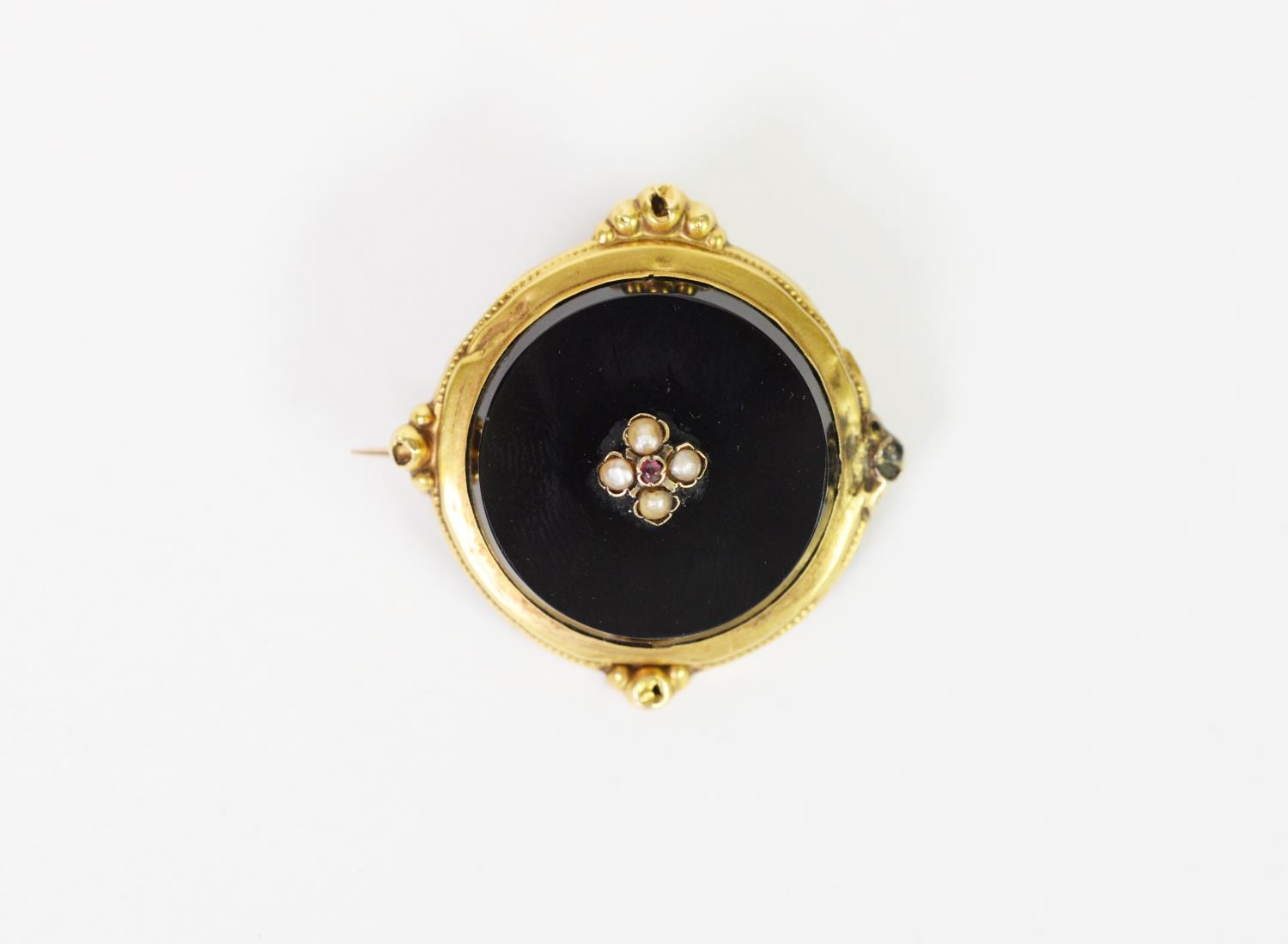 VICTORIAN CIRCULAR BLACK ONYX BROOCH, the centre overlaid with a small cluster of four seed pearls