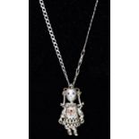 PIERCED WHITE METAL VINTAGE ARTICULATED RAG DOLL PENDANT, depicted with pigtails and having gem