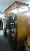 A GEORGE V INLAID MAHOGANY TWO DOOR WARDROBE WITH OVAL MIRRORS, HAVING TWO DEEP DRAWERS TO THE BASE,