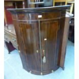 A GEORGE III INLAID MAHOGANY BOW FRONTED CORNER CUPBOARD WITH SPICE DRAWER