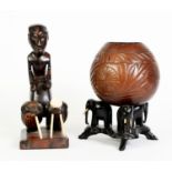 AFRICAN CARVED EBONY FIGURE OF A DRUMMER, modelled standing behind two drums with carved bone