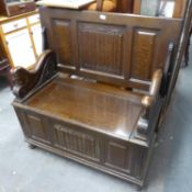 AN OAK MONKS BENCH, HAVING LIFT-UP TOP AND TO FORM BACK, THE SEAT SECTION ALSO WITH LIFT-UP LID TO