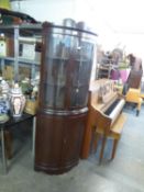 A DARK MAHOGANY BOW FRONTED DOUBLE CORNER CUPBOARD WITH SHAPED PEDIMENT, TWO BOW GLAZED DOORS OVER