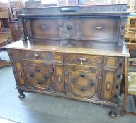 A LARGE HEAVY OAK EARLY TO MID TWENTIETH CENTURY SIDEBOARD, WITH CARVING TO DOORS AND DRAWERS,