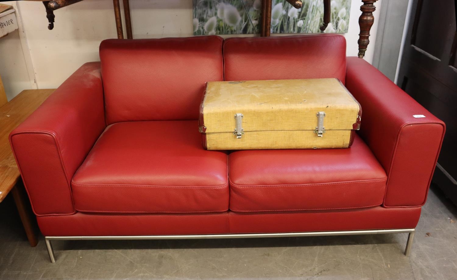 A STYLISH RED LEATHER SOFA ON CHROME BASE