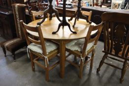 A WAXED PINE CIRCULAR DINING TABLE AND FOUR RUSH-SEATED DINING CHAIRS (5)