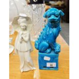 CHINESE BLUE GLAZED POTTERY DOG OF FO ORNAMENT AND AN ITALIAN PORCELAIN FEMALE FIGURE, WITH UMBRELLA