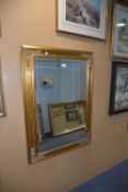 RECTANGULAR BEVELLED EDGE WALL MIRROR, IN GILT FRAME WITH SCROLL EMBOSSED CORNERS, 31” x 43” ( 78.