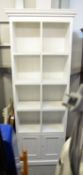 TALL PINE, PAINTED WHITE BOOKCASE, HAVING CUBE SHELVING AND CUPBOARD DOORS, ON PLINTH BASE, 208cm