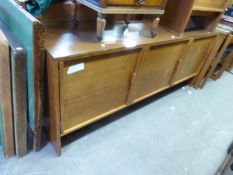 A MID-CENTURY TEAK LONG LOW SIDEBOARD, HAVING 3 CUPBOARD DOORS, AN OBLONG EXTENDING DINING TABLE AND