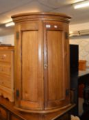 OAK BOW FRONTED HANGING CORNER CUPBOARD, ENCLOSED BY TWO DOORS
