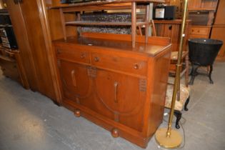 A MID-CENTURY CARVED OAK ENCLOSED SIDEBOARD, WITH TWO CUPBOARD DOORS, ON PLINTH BASE