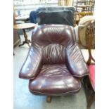 AN OAK AND LEATHER REVOLVING ARMCHAIR, RECENTLY RE-UPHOLSTERED IN BURGUNDY, HAVING OAK SIDE ARMS AND