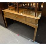 A 'STAG' LIGHT OAK DESK/SIDE TABLE, HAVING ONE LONG AND TWO SHORT DRAWERS