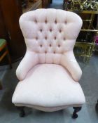 A REPRODUCTION BUTTON BACK NURSING CHAIR, COVERED IN PINK FABRIC, RAISED ON CABRIOLE LEGS
