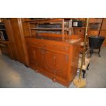 A MID-CENTURY CARVED OAK ENCLOSED SIDEBOARD, WITH TWO CUPBOARD DOORS, ON PLINTH BASE