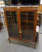 A MAHOGANY SMALL TWO GLAZED DOOR BOOKCASE, RAISED ON CABRIOLE LEGS