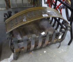 A BLACK CAST IRON DOG GRATE AND AN ANTIQUE PIERCED BRASS SMALL CURVED FENDER