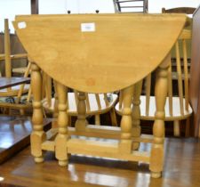 A LIGHT OAK CIRCULAR FALL-LEAF COFFEE TABLE