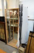 A SHOP DISPLAY; SIX FOLD TUBULAR METAL AND MUSLIN ROOM DIVIDER AND GLASS TWO DOOR DISPLAY CABINET