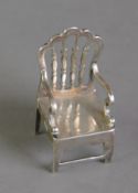 GEORGE V SILVER MINIATURE MODEL OF AN OPEN ARMCHAIR, stamped: TENNYSON 1809-1892, 2” (5.1cm) high,