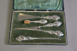LADY’S CASED FOUR PIECE VANITY SET IN STEEL WITH FILLED SILVER HANDLES, comprising: SHOE HORN, SMALL