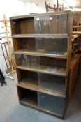 A 'MINTY' FIVE TIER SECTION LIBRARY BOOKCASE, HAVING GLASS SLIDING DOORS (1 GLASS DOOR MISSING)