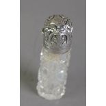 LATE VICTORIAN CUT GLASS SCENT BOTTLE WITH EMBOSSED SILVER LID, of cylindrical form with leaf and