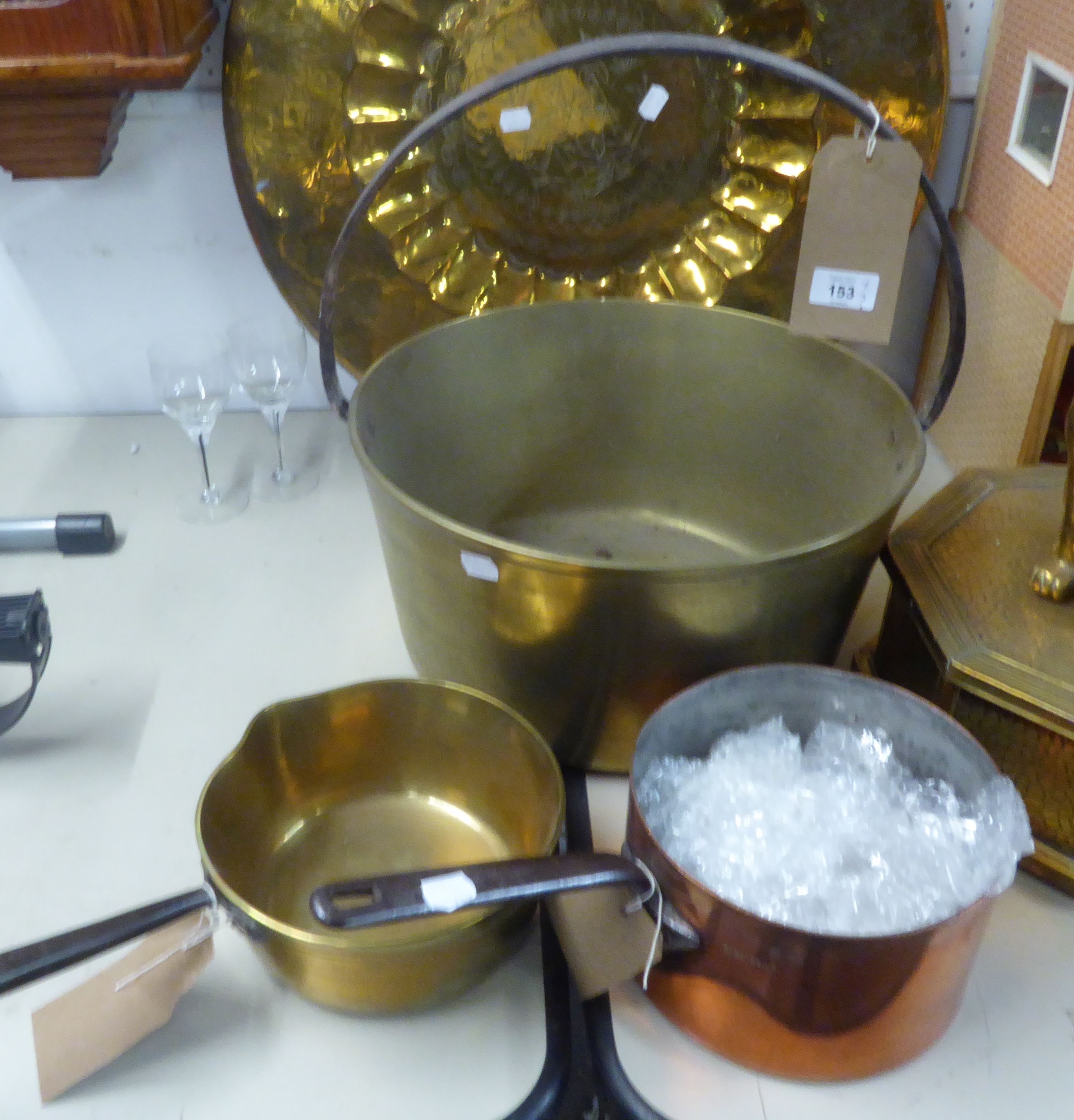 A LARGE CIRCULAR BRASS JAM PAN, WITH IRON HOOP HANDLE, 15” DIAMETER; A HEAVY BRASS SAUCE PAN WITH