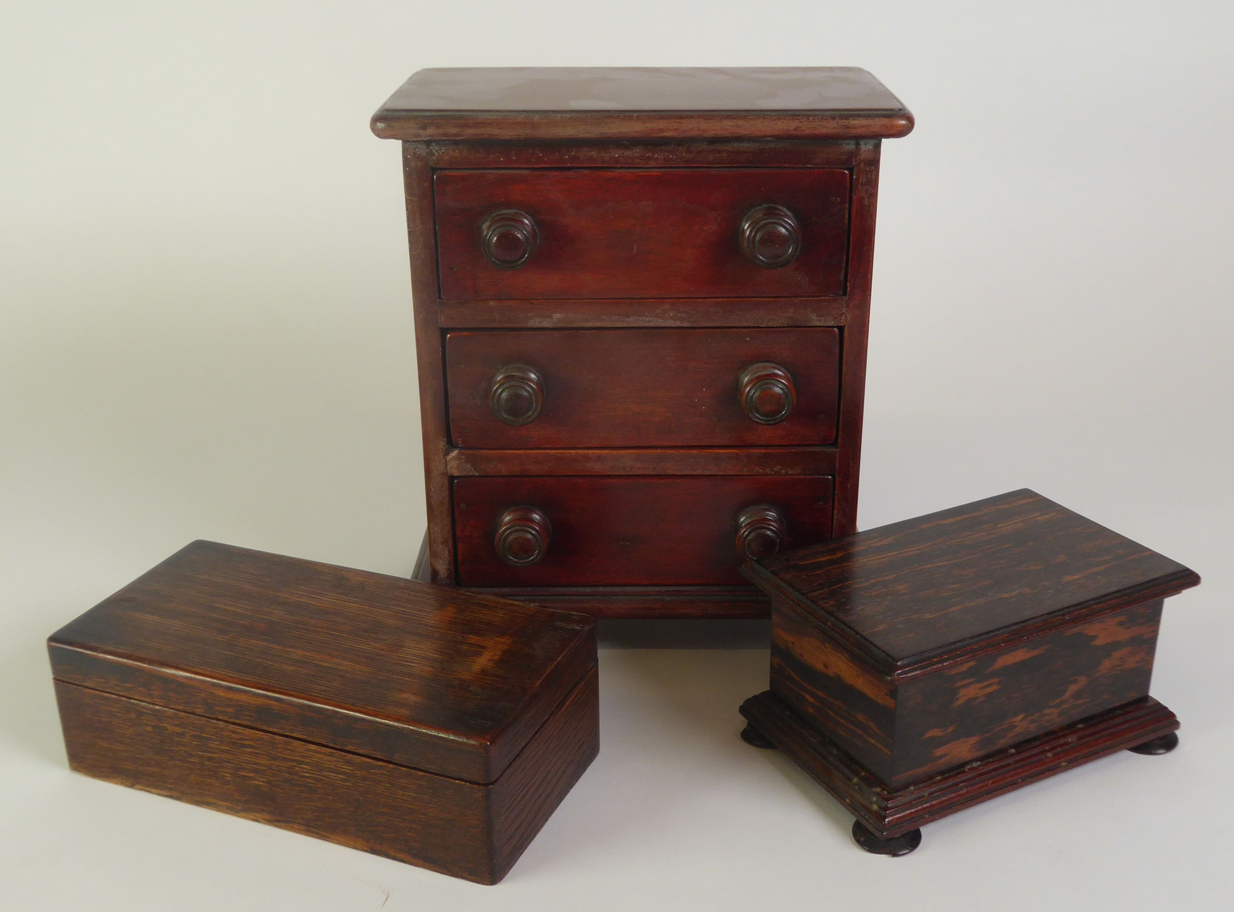 EARLY TWENTIETH CENTURY EBONY MONEY BOX, of moulded oblong form with bun type feet and slot to the