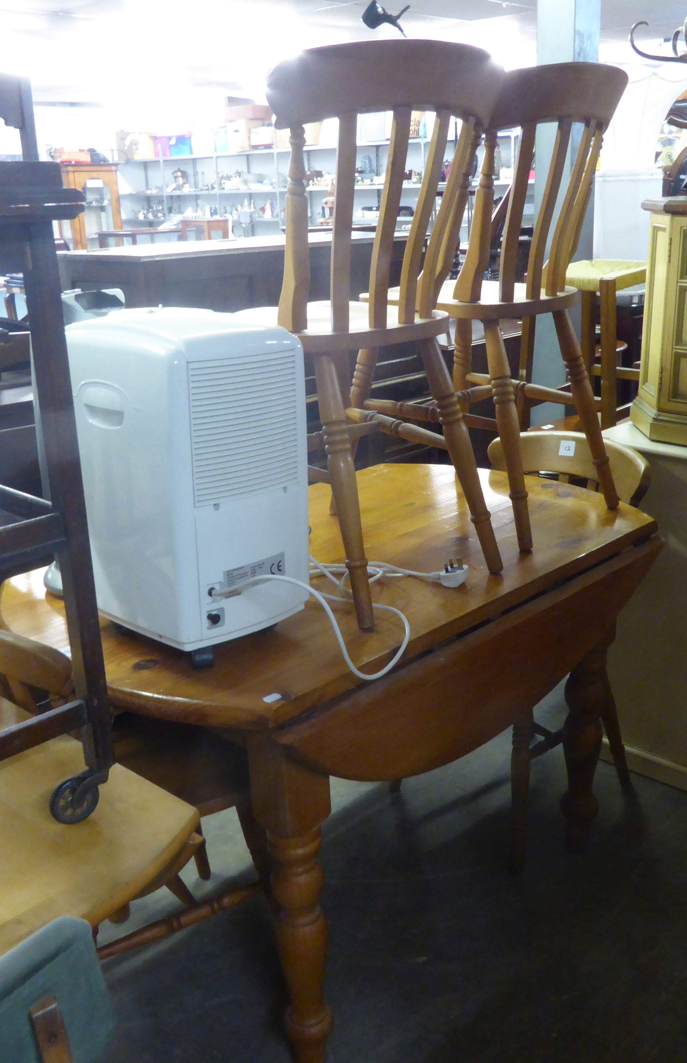 A 4'6" CIRCULAR PINE DROP-LEAF DINING TABLE AND FOUR PINE DINING CHAIRS (5)