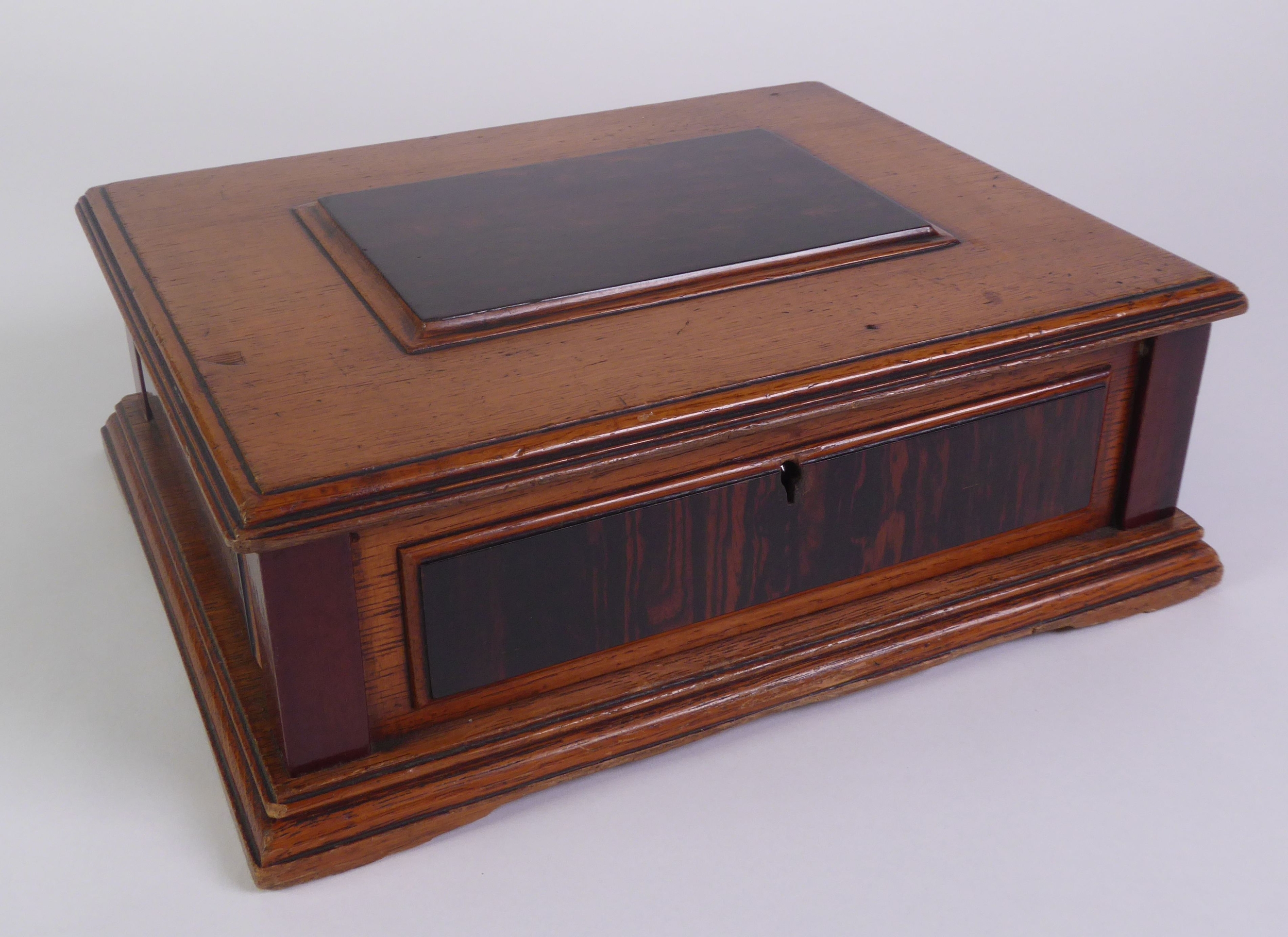 EARLY TWENTIETH CENTURY OAK, EBONY AND MAHOGANY TABLE CIGAR BOX. With raised panels to the top and