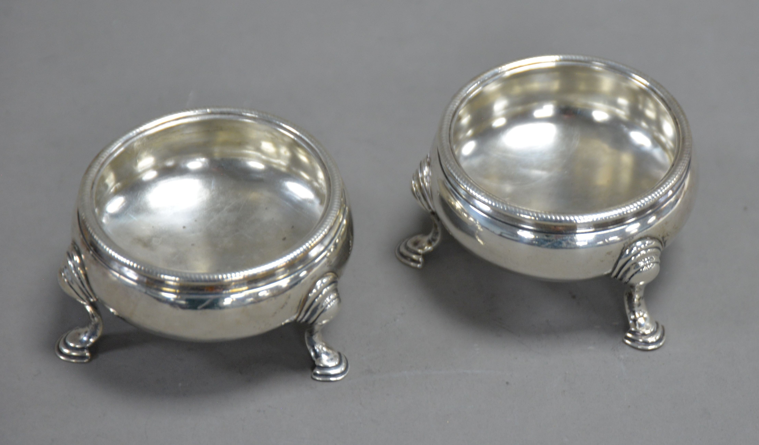 PAIR OF EARLY GEORGE III SILVER CAULDRON-SHAPE SALT-CELLARS with cabled rims, each on three