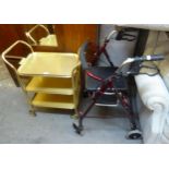 A GILT METAL THREE TIER TEA TROLLEY AND A SIDE-FOLDING WALKING FRAME, WITH BRAKES (2)