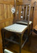 A PAIR OF OAK ARTS & CRAFTS STYLE RAIL BACKED DINING CHAIRS, WITH FLORAL TAPESTRY PAD SEATS