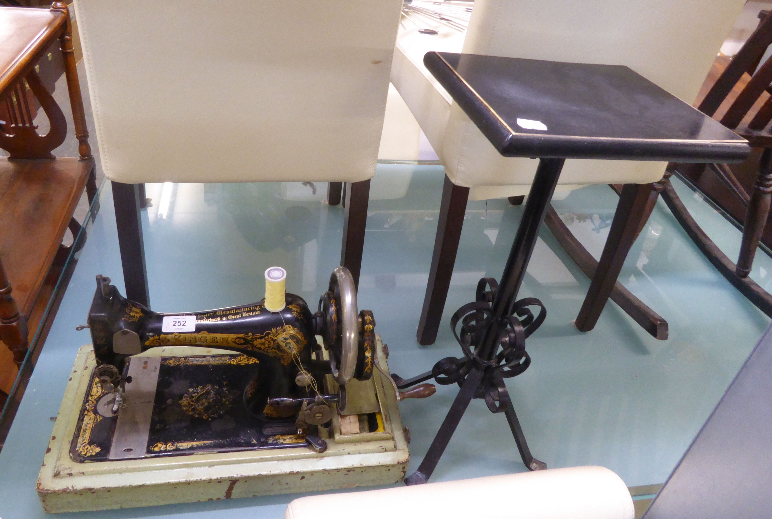 AN OLD SINGER SEWING MACHINE AND A SMALL WROUGHT IRON STAND (2)