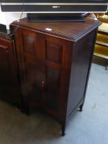 AN EDWARD VII MAHOGANY MUSIC CABINET, HAVING TWO PANEL DOORS, RAISED ON SQUARE TAPERING LEGS