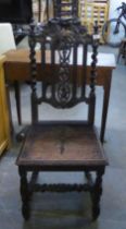 AN ANTIQUE CARVED OAK HALL CHAIR WITH PANEL SEAT