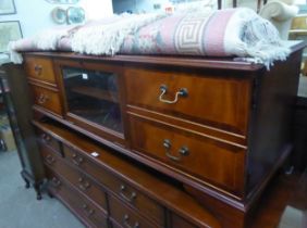 A LONG LOW MAHOGANY REPRODUCTION ENTERTAINMENT CABINET, HAVING A GLAZED CENTRAL DROP-DOWN SECTION