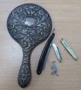 AN EMBOSSED SILVER BACKED HAND MIRROR (A.F.), A PENKNIFE WITH SILVER BLADE, ANOTHER PENKNIFE, A
