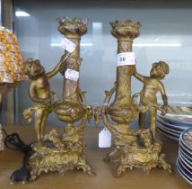 A PAIR OF CIRCA 1900's CONTINENTAL GILT METAL CANDLESTICKS DECORATED WITH CHERUBS