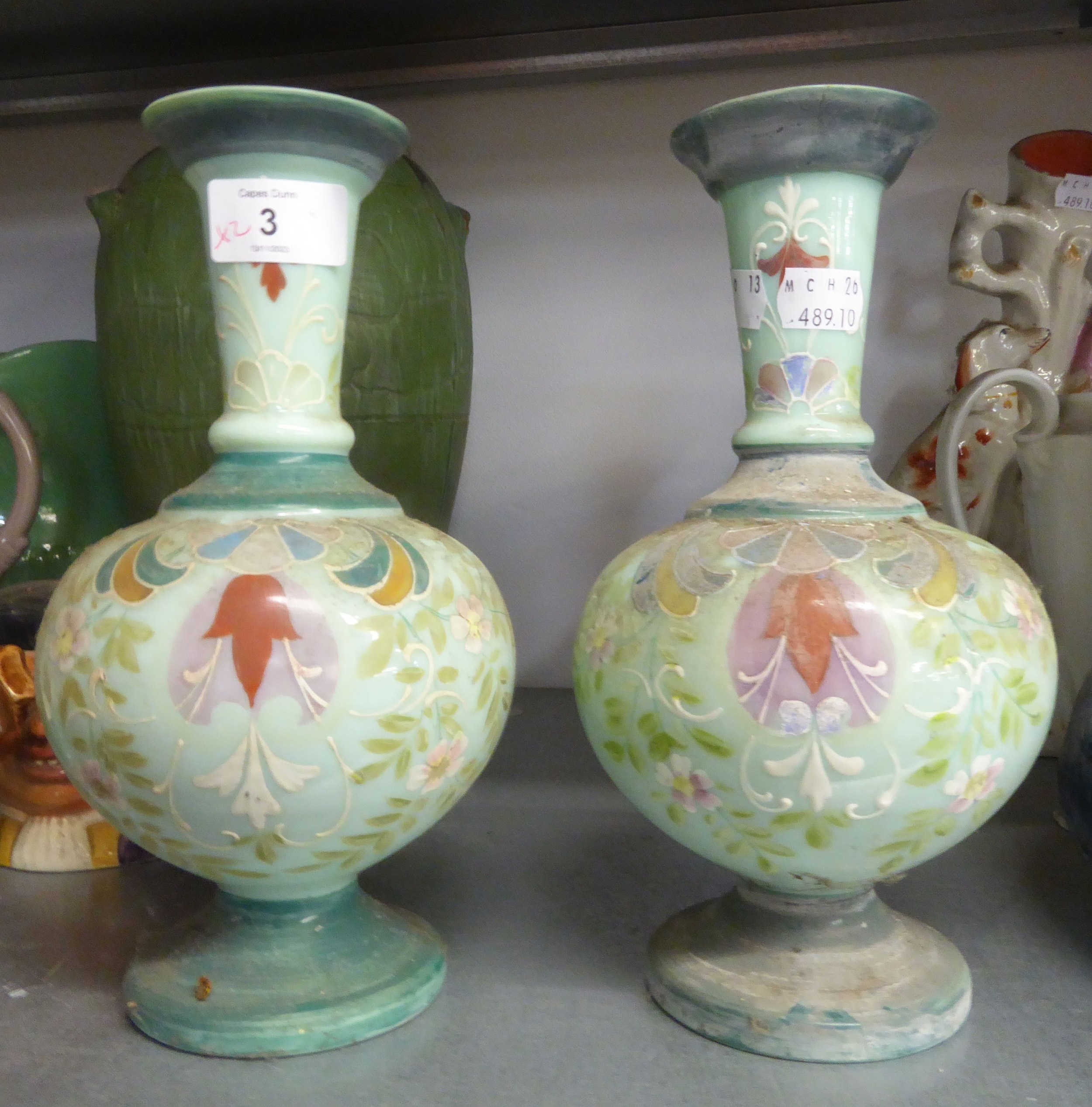 A PAIR OF GREEN COLOURED GLASS GLOBE AND SHAFT SHAPED VASES WITH FLORAL DECORATION